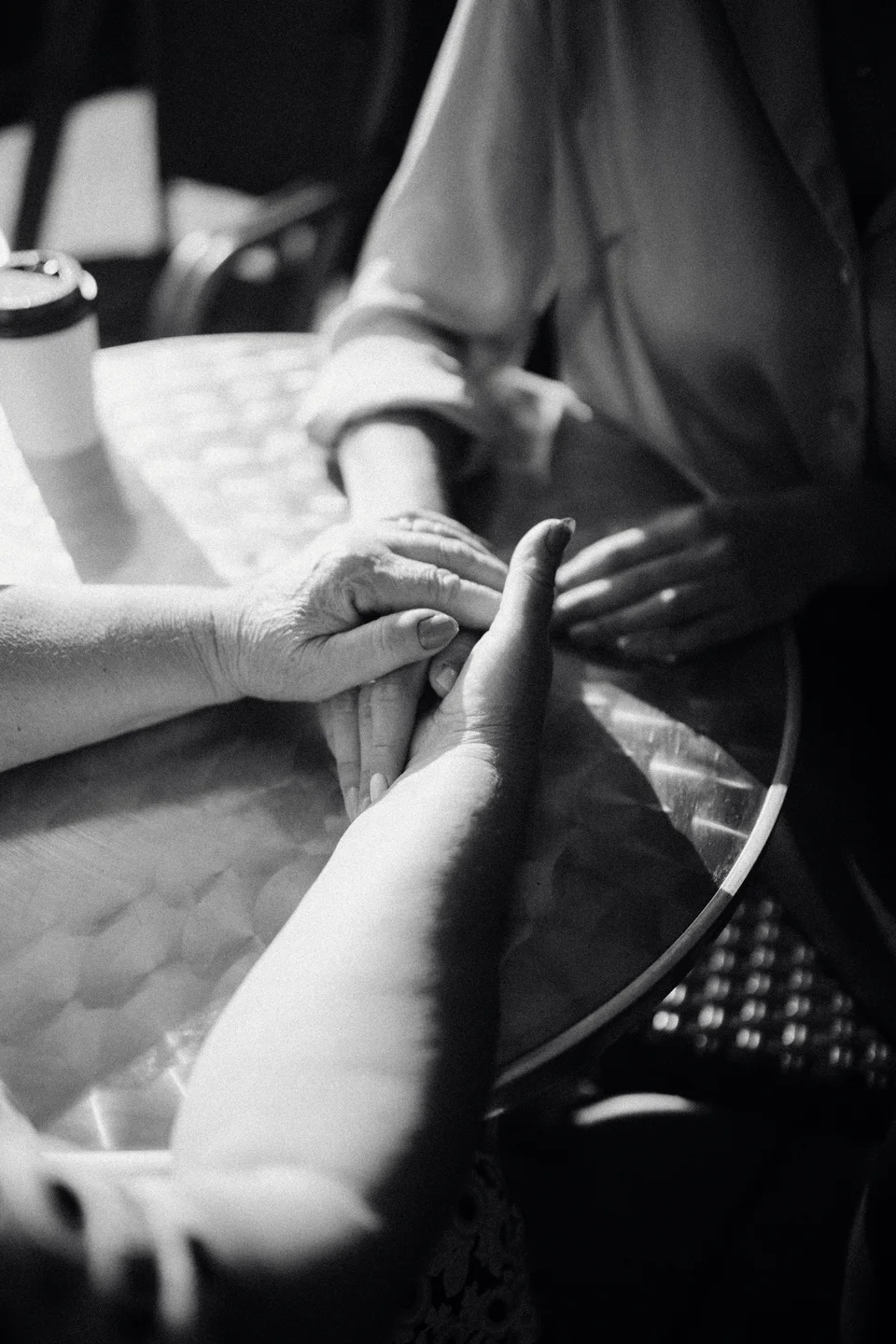 Two people holding hands across a table